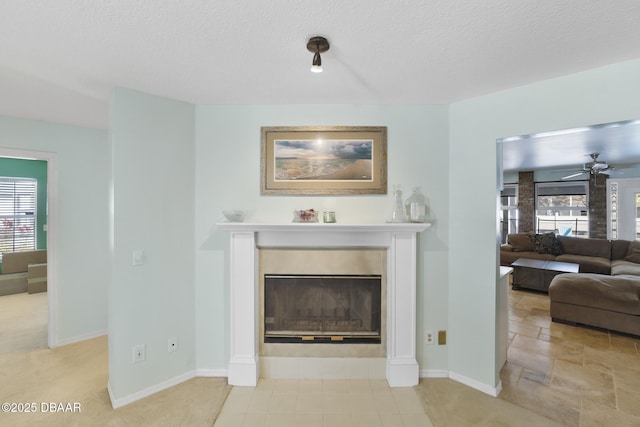 living area with plenty of natural light, a fireplace, baseboards, and a textured ceiling