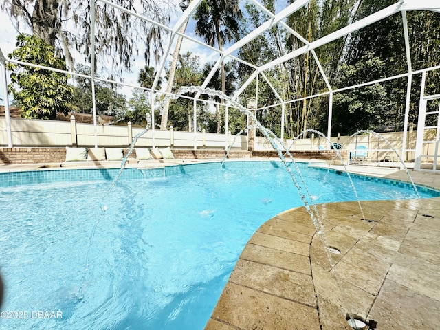 view of swimming pool featuring a fenced in pool, a fenced backyard, glass enclosure, and a patio area