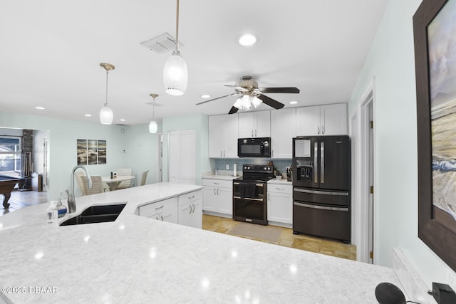 kitchen featuring visible vents, black appliances, a sink, tasteful backsplash, and white cabinetry