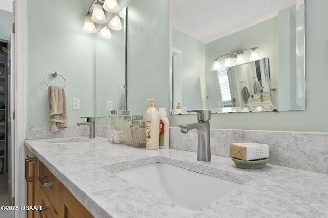 full bath with a sink, a walk in closet, and double vanity