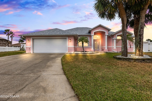 view of front of house featuring a garage and a lawn