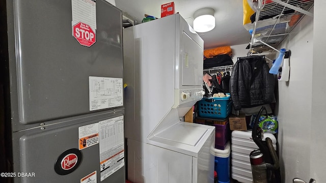 clothes washing area featuring stacked washer / drying machine and heating unit