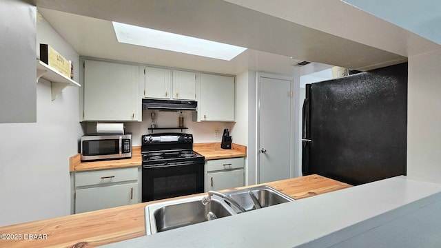 kitchen featuring black appliances, sink, and wooden counters