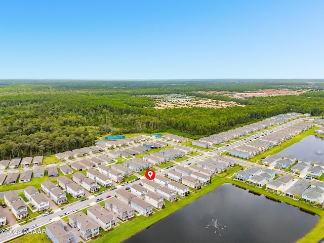 drone / aerial view featuring a residential view, a water view, and a wooded view