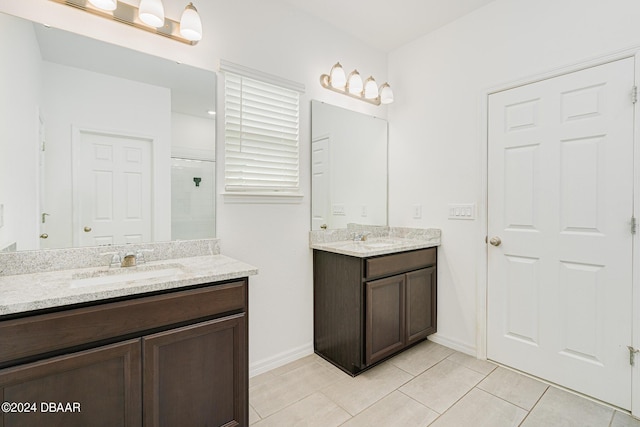 full bathroom featuring two vanities, a shower stall, a sink, and tile patterned flooring