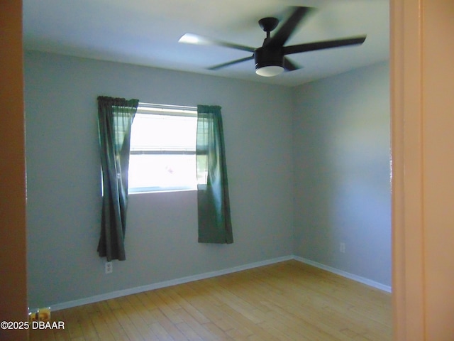 empty room featuring baseboards, light wood-style floors, and ceiling fan