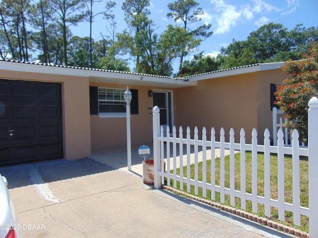 view of front facade with stucco siding and fence