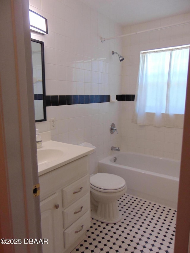 full bathroom featuring tile patterned floors, vanity, tub / shower combination, tile walls, and toilet