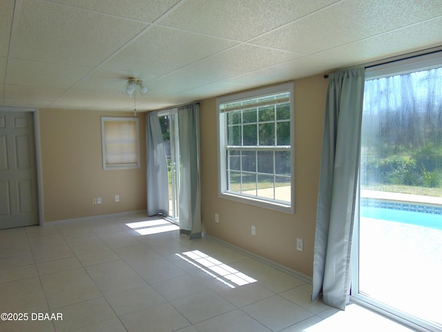 spare room with baseboards, a healthy amount of sunlight, and light tile patterned floors