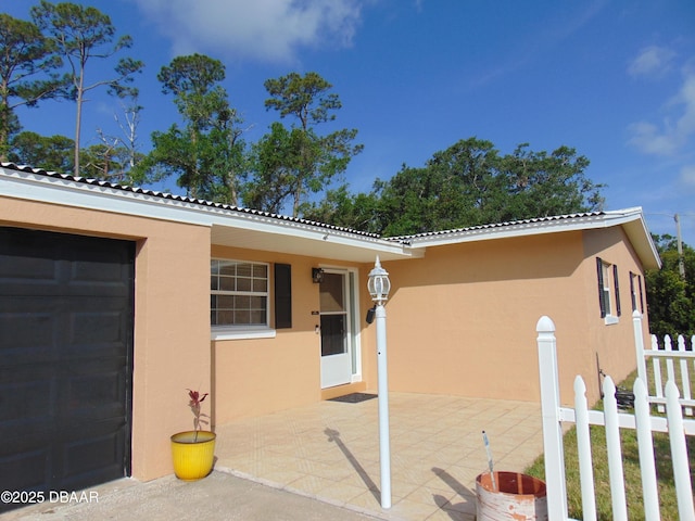 exterior space with a tile roof, a patio, stucco siding, and fence