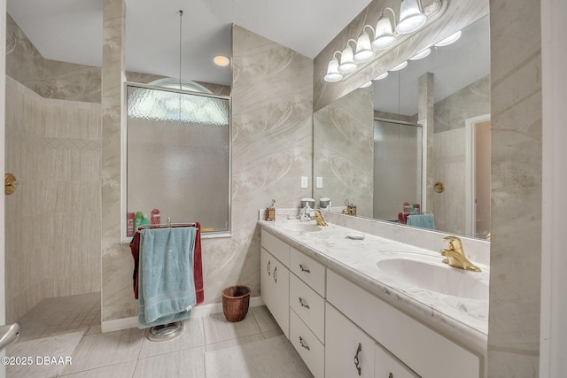 bathroom with tile patterned floors, vanity, tile walls, and tiled shower