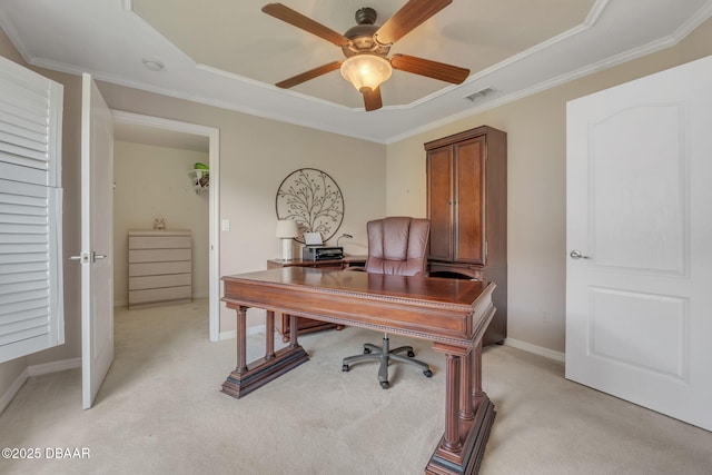 carpeted home office featuring a raised ceiling, ceiling fan, and ornamental molding