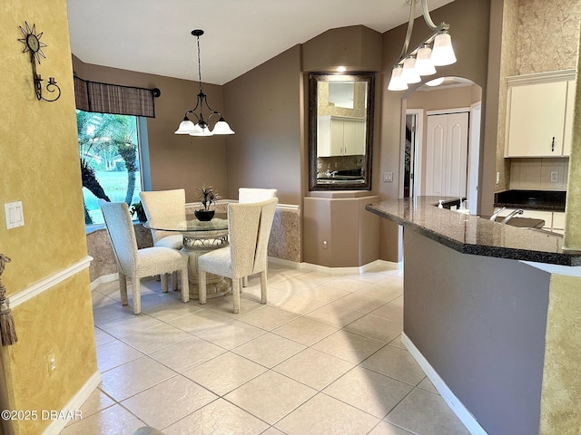 dining room featuring light tile patterned flooring and an inviting chandelier