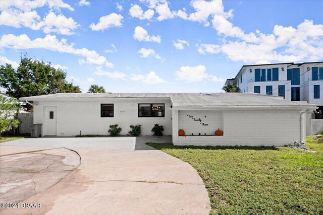 223 Sandy Cir S, Daytona, FL 32119 - view of front of property with a front yard, brick siding, and driveway