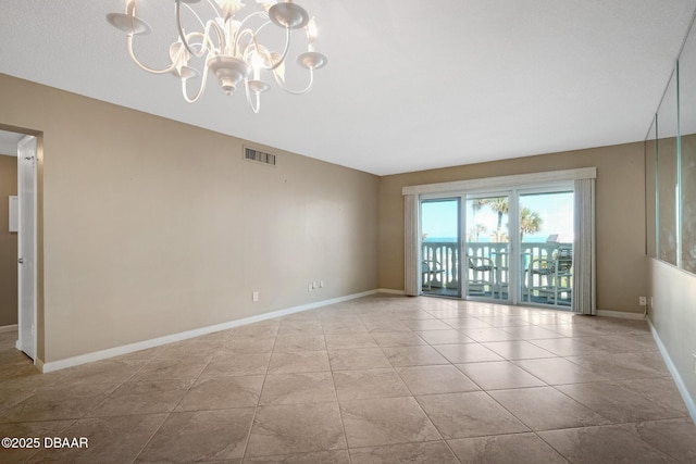 tiled empty room with a notable chandelier