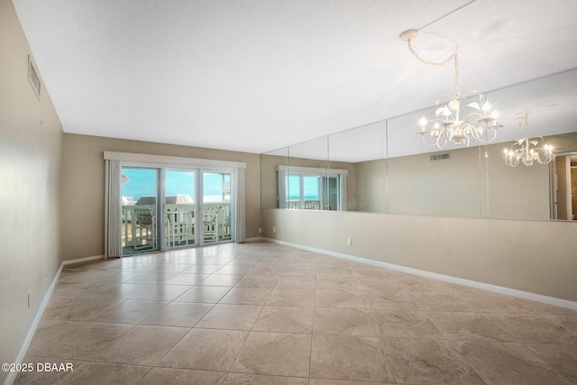 tiled empty room featuring a chandelier