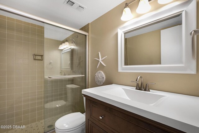 bathroom with vanity, an enclosed shower, and toilet