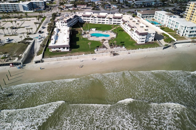 birds eye view of property with a water view and a beach view