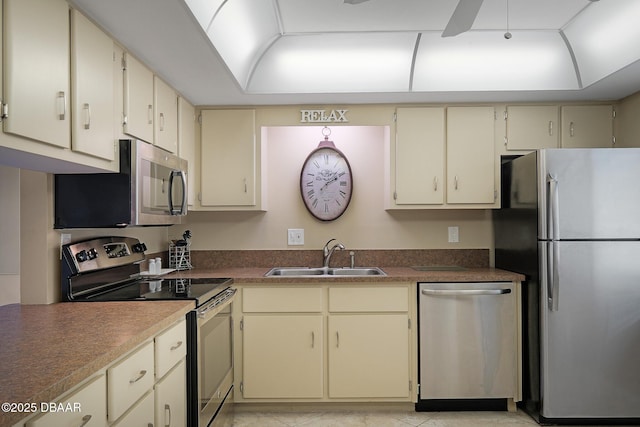 kitchen featuring stainless steel appliances, cream cabinets, and sink