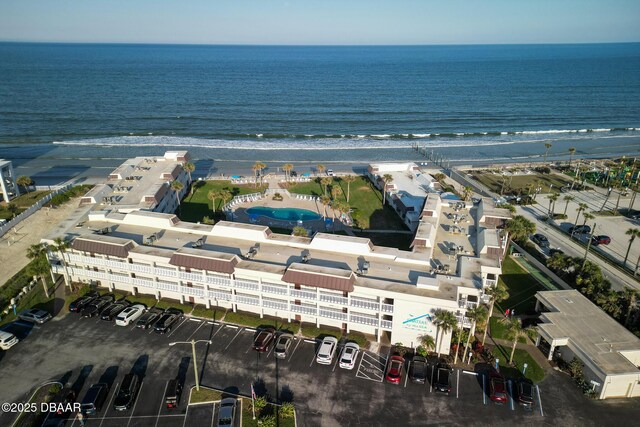 drone / aerial view with a water view and a beach view