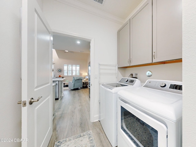 laundry room featuring cabinets, crown molding, separate washer and dryer, and light hardwood / wood-style flooring