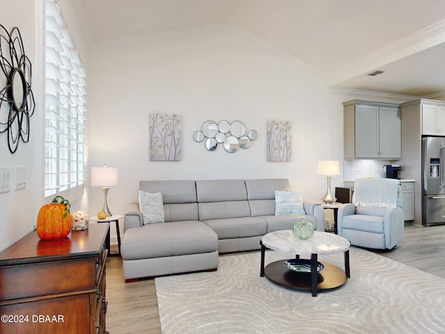 living room with light wood-type flooring, crown molding, and vaulted ceiling