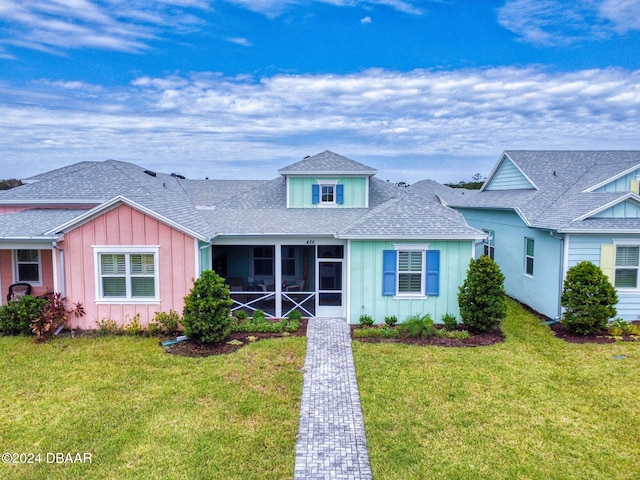 view of front of home featuring a front yard and a sunroom