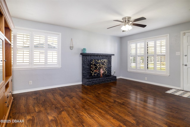 unfurnished living room with a healthy amount of sunlight, a fireplace, baseboards, and wood finished floors