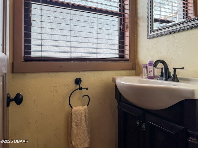 bathroom with a wealth of natural light and a textured wall