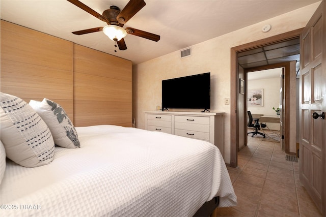 bedroom featuring light tile patterned floors, visible vents, and a ceiling fan