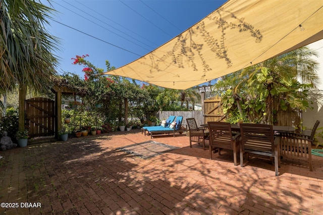 view of patio / terrace featuring outdoor dining area, fence, and a gate