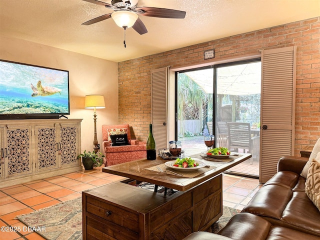 living room with light tile patterned flooring, brick wall, a textured ceiling, and ceiling fan