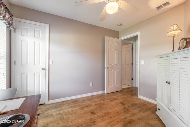 bedroom with ceiling fan, light hardwood / wood-style floors, multiple windows, and a closet