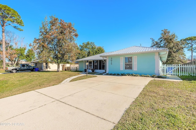 single story home with a front lawn and a sunroom