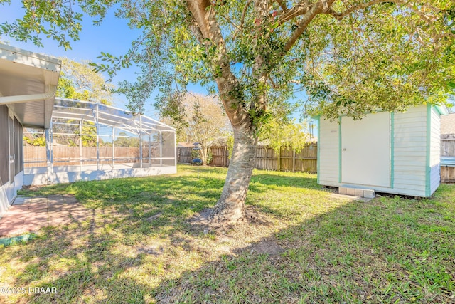 view of yard featuring a shed and glass enclosure