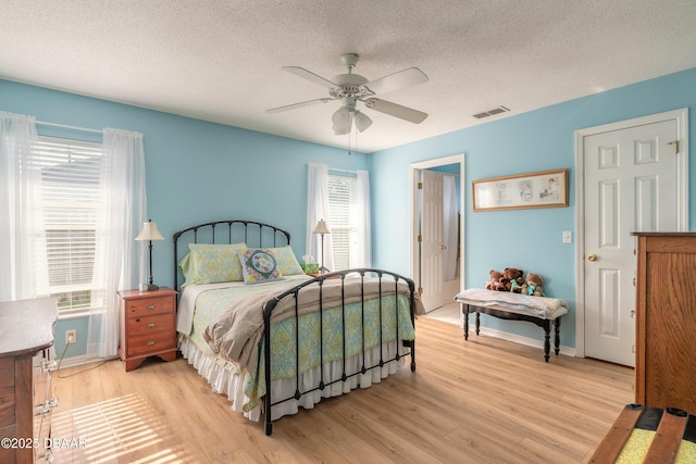 bedroom featuring multiple windows, ceiling fan, and light wood-type flooring