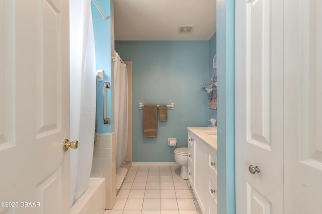 bathroom with curtained shower, tile patterned flooring, a textured ceiling, toilet, and vanity