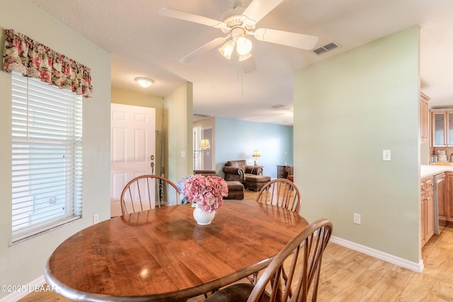 dining space featuring ceiling fan and light wood-type flooring