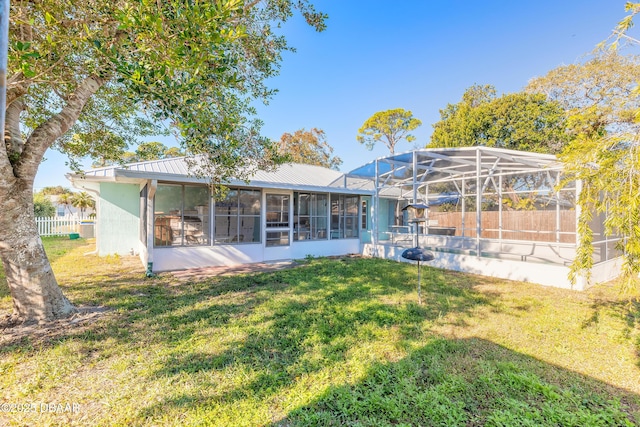 back of house featuring a lawn and glass enclosure