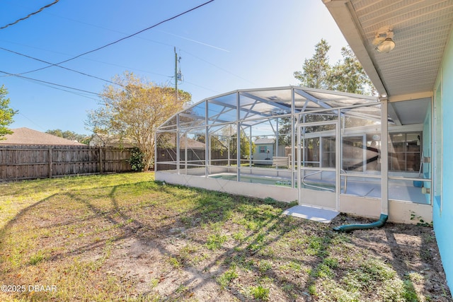 view of yard featuring a fenced in pool and glass enclosure