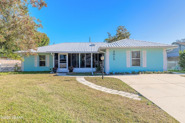 single story home featuring a sunroom and a front yard