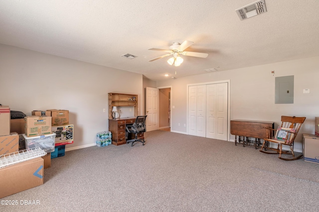 carpeted home office featuring a textured ceiling, electric panel, and ceiling fan