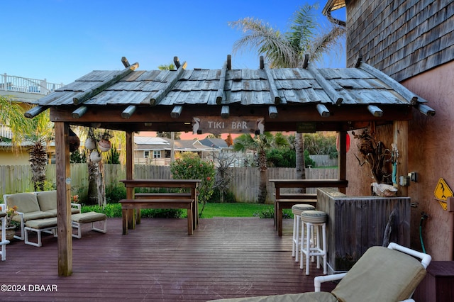 wooden terrace with exterior bar and an outdoor hangout area