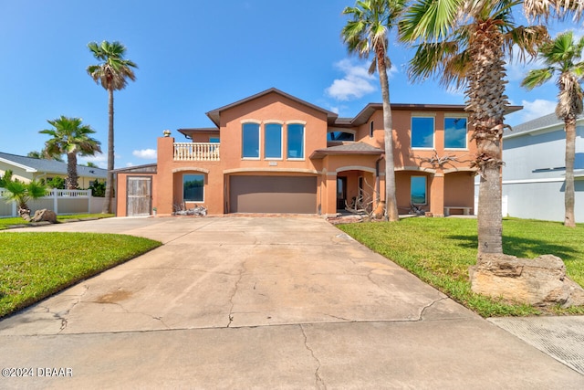 view of front facade with a balcony, a front lawn, and a garage