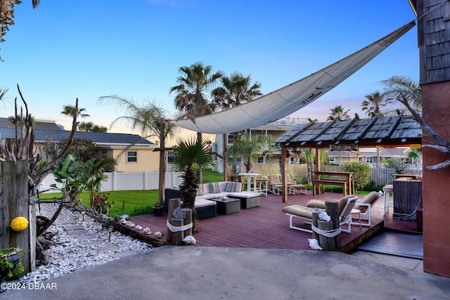 deck at dusk with outdoor lounge area and a pergola