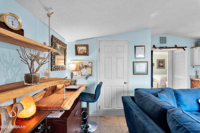 home office with vaulted ceiling, light tile patterned floors, and a textured ceiling