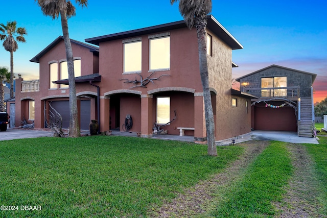 view of front of home with a yard, a balcony, and a garage