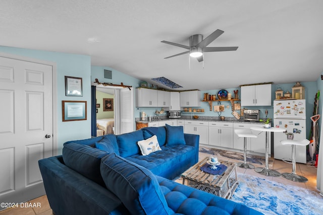 tiled living room featuring ceiling fan and lofted ceiling