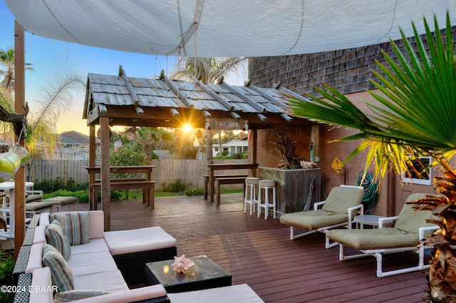 deck at dusk with a bar and an outdoor hangout area