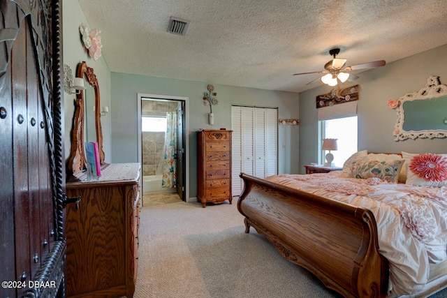 carpeted bedroom featuring ceiling fan, a textured ceiling, and connected bathroom